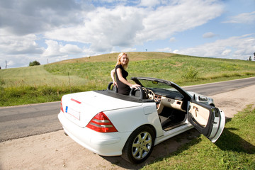 Portrait of the beautiful young girl on nature with cabriolet