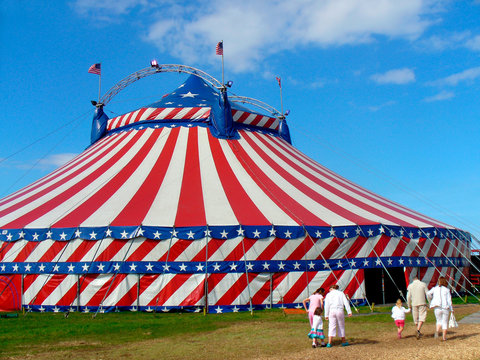 Circus big top tent in field decorated with stars and stripes.