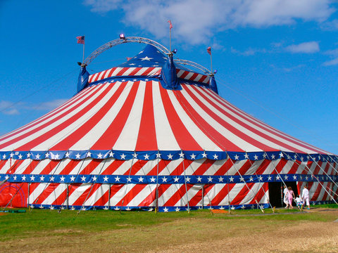 Circus big top tent in field decorated with stars and stripes.