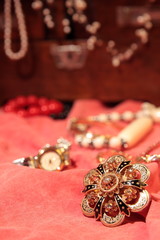 Beautiful golden brooch on red surface