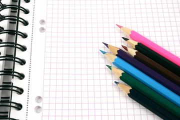 colorful pencils on notebook
