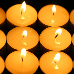 sacred candles in dark on black background