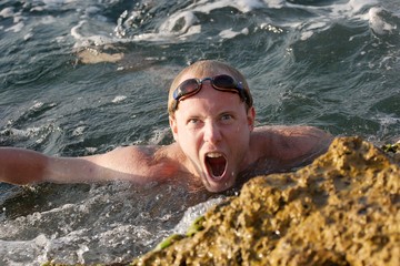 Roaring man swimming in the waves