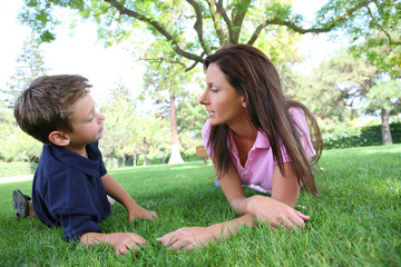 A mother and son talking while relaxing in the park