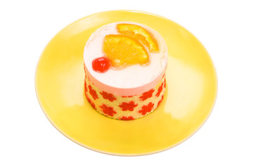 Cake with a cherry and an orange on a yellow plate