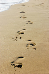 footprints on empty sand beach