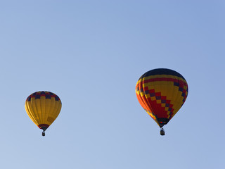 two hot air balloons in german colors in blue sky