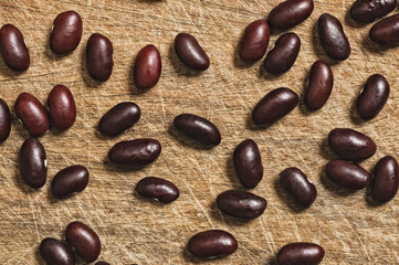 Brown beans over an old wooden table.