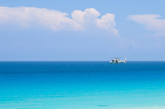 Coast guard helicopter hovering above turquoise tropical ocean © nfsphoto