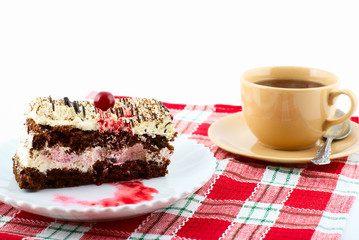 Piece of cake on white plate and  cup of tea