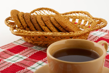 Biscuits in the straw basket and a cup of tea