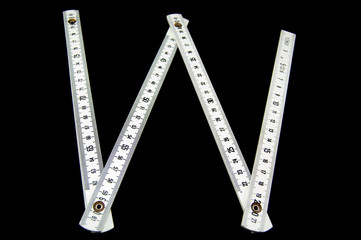 open white folding rule "W" shaped on black background