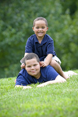 Naklejka na ściany i meble Two brothers playing on fresh green grass