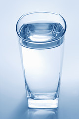 Glass of water on a blue background