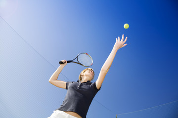blond woman playing tennis, about to hit the ball. Copy space
