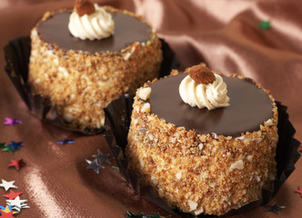 Two miniature chocolate meringue cakes with cream