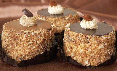 Three miniature chocolate meringue cakes with cream