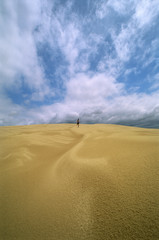 Man in the distance running across sand flats,
