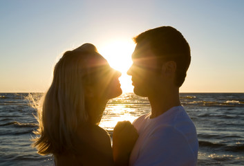 Couple hugging, enjoying summer sunset.