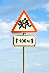 Road sign on a background of the sky. Caution, children!