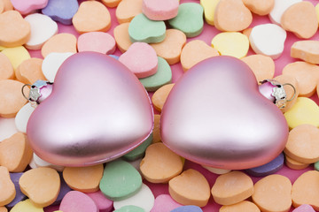Two heart ornaments on candy hearts