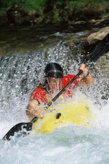 Young man kayaking in river