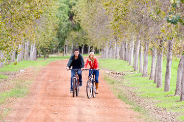 A young couple on bikes in a country lane