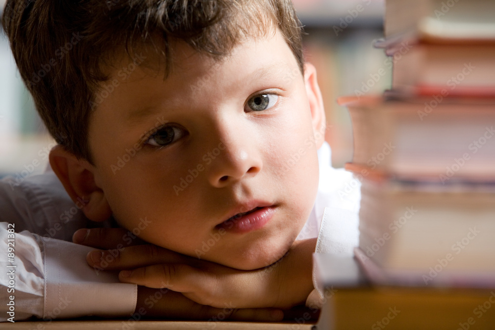 Canvas Prints Close-up of little boy’s face with pile of books near by