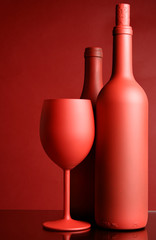 Still-life with red wine bottles and glass