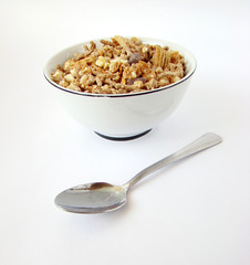 Cup of cereals with spoon on white background.