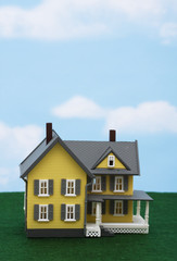 Model house on grass with sky background
