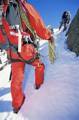 Foto op Canvas Young men mountain climbing on snowy peak © Monkey Business