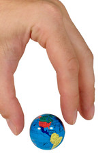 Human fingers ready to seize a small globe (isolated on white)