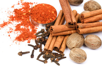 Red pepper, cinnamon sticks, nutmeg and cloves isolated on white