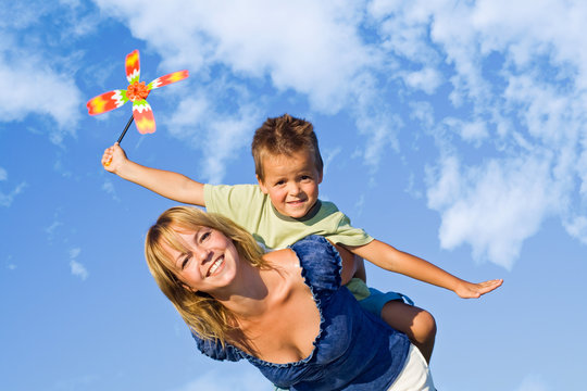 Woman and little boy playing with windmill toy