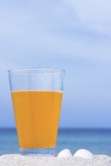 Glass of soft drink on tropical beach
