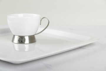 White porcelain cup on white plate