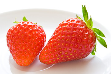 two strawberries on white dish