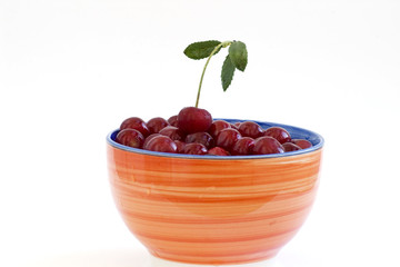 Ripe sweet cherry in a plate on white background