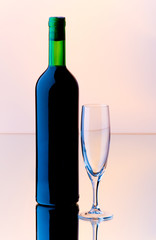Bottle and wine glass on reflective background