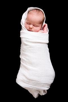 Baby Cocoon. Swaddled 15 days old newborn over black background