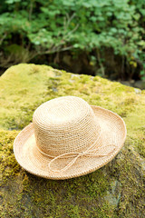Straw raffia Hat on rock by river