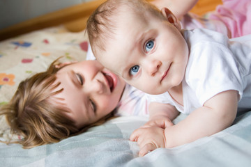 little brother and sister playing together, on white