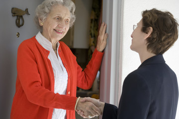 Attractive senior woman shaking hands with visitor © edbockstock