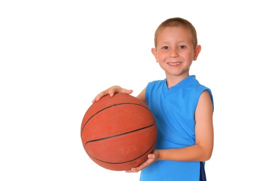 Young boy playing with a basketball isolated on white
