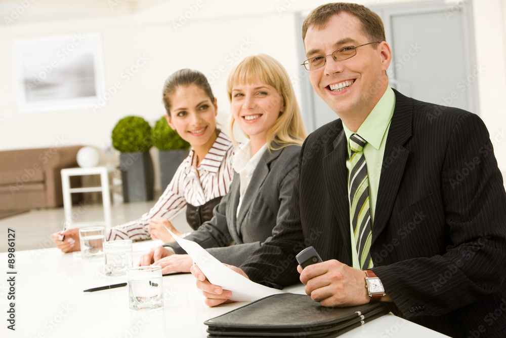 Wall mural row of successful business people sitting at the table