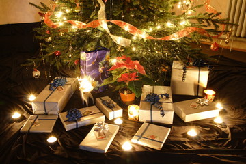 Christmas presents and candles under the tree