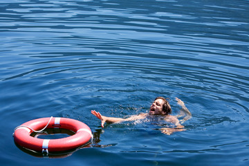 A man struggling for a life buoy in the water