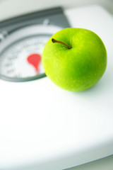 green apple sitting on a bathroom scale