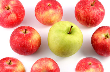 A lot of red and one green apple on a light background